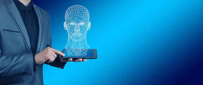 man holding a laptop with a digital face on it