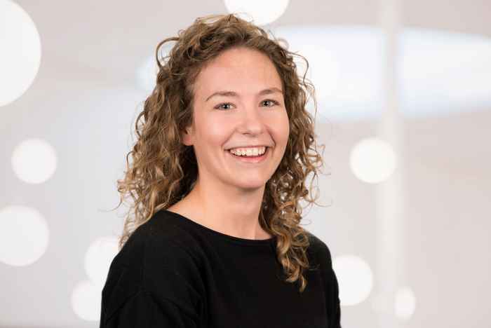 Portret van een docent met krullend haar en zwarte trui