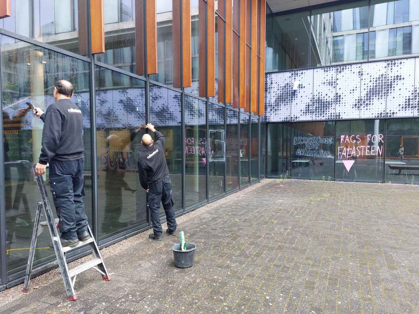 Een afbeelding van schoonmakers die een gebouw schoon spuiten op het Science Park