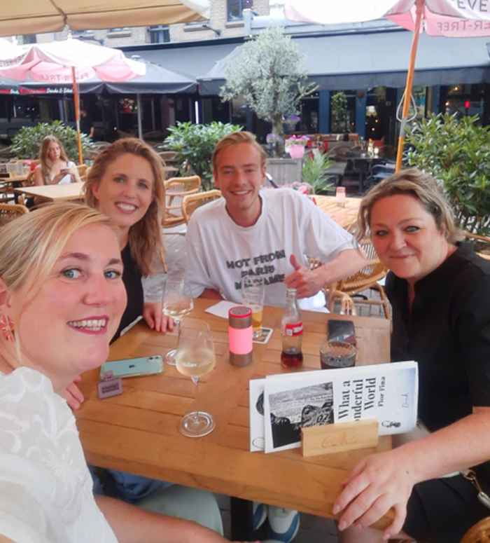Mees en zijn stagebegeleiders drinken iets op het terras